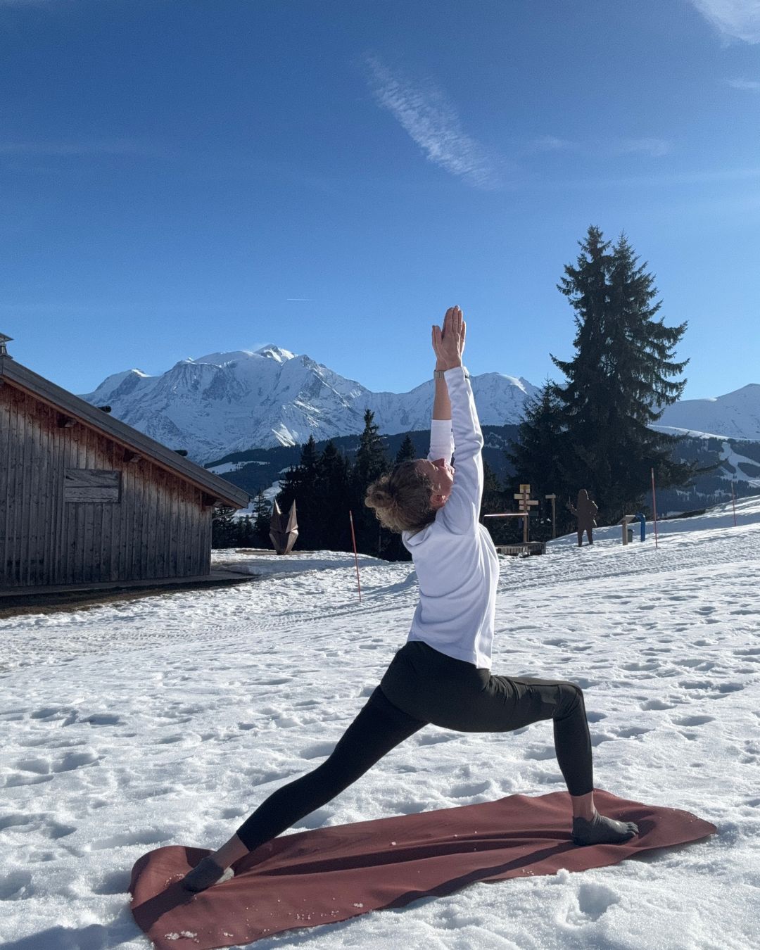 Virabhadrasana, guerrier 1 dans la neige Posture du guerrier devant le chalet de Beauregard à Comboux